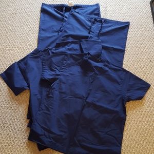 Two pairs Allheart navy scrubs.